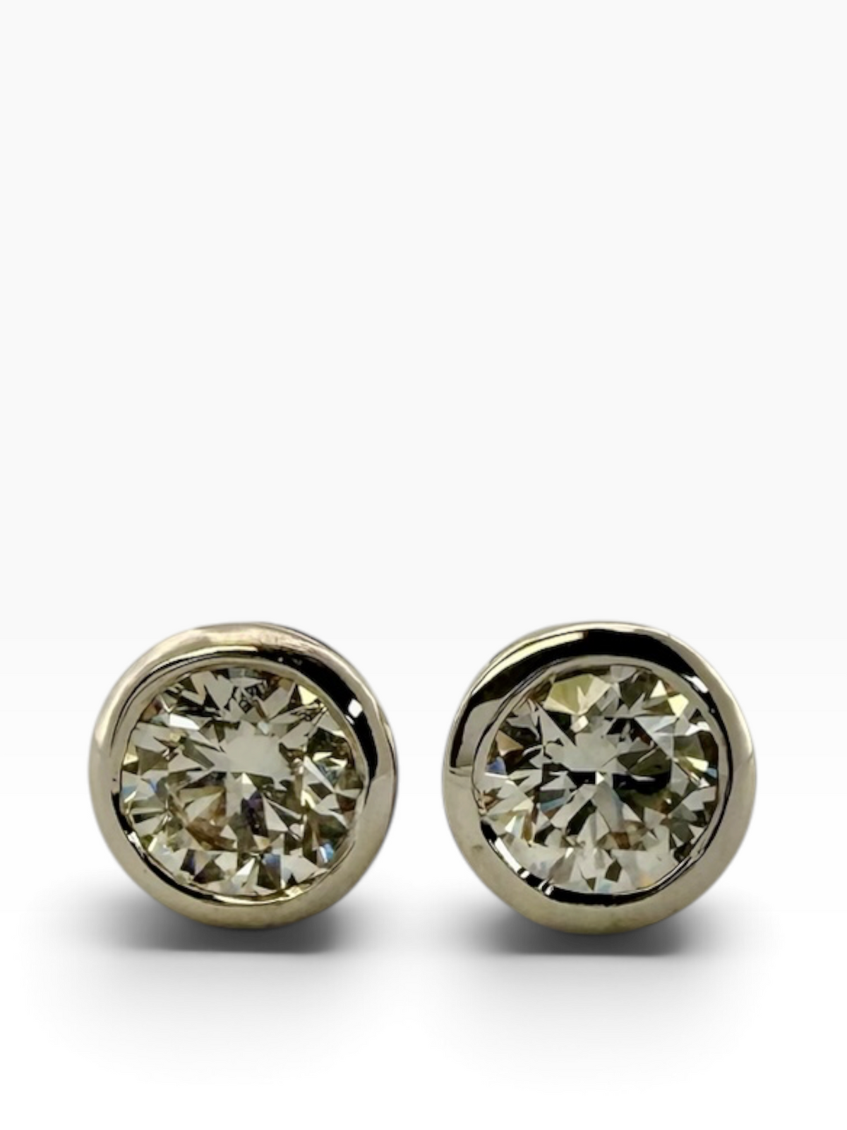 Pair of rub-over set diamond solitaire earrings