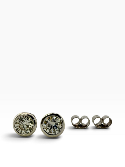 Pair of rub-over set diamond solitaire earrings