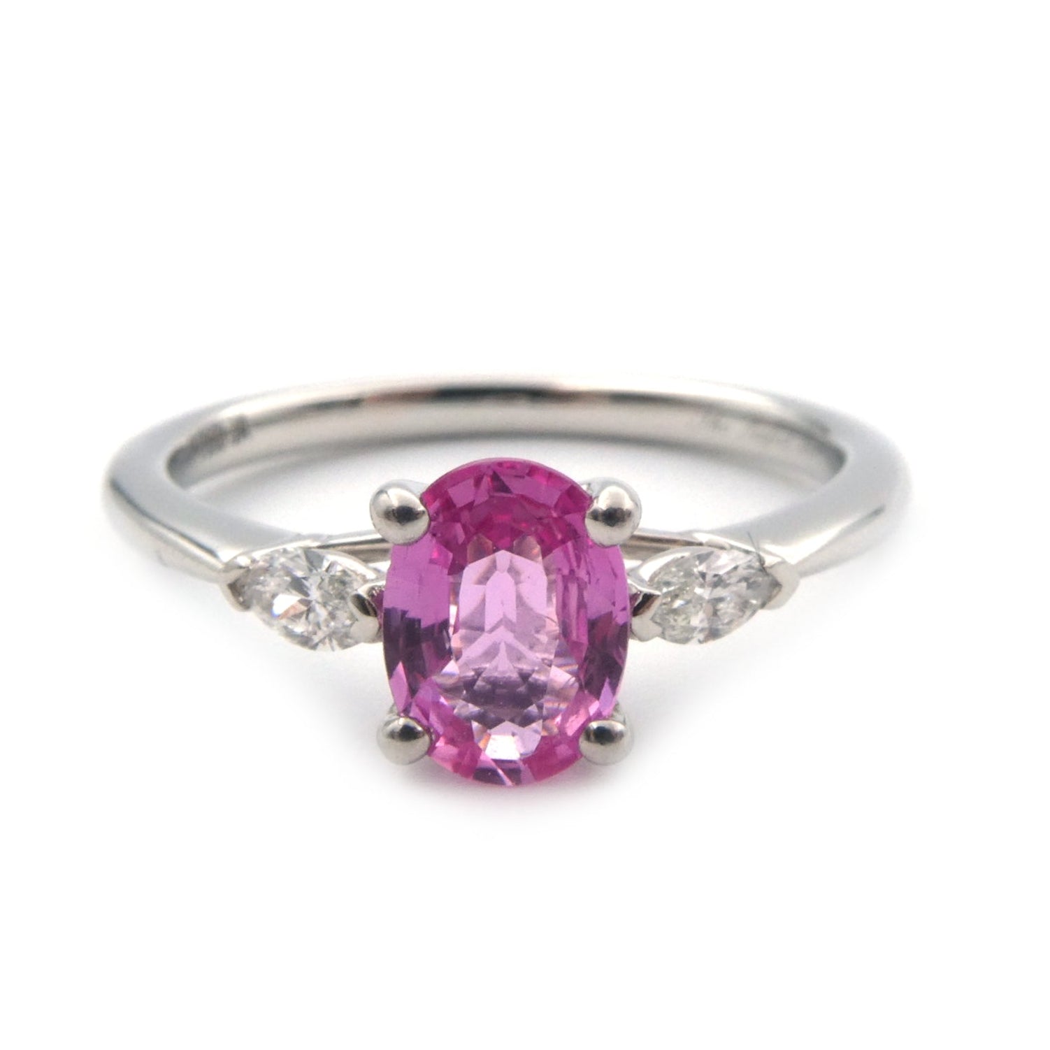 A pink sapphire and diamond three stone ring