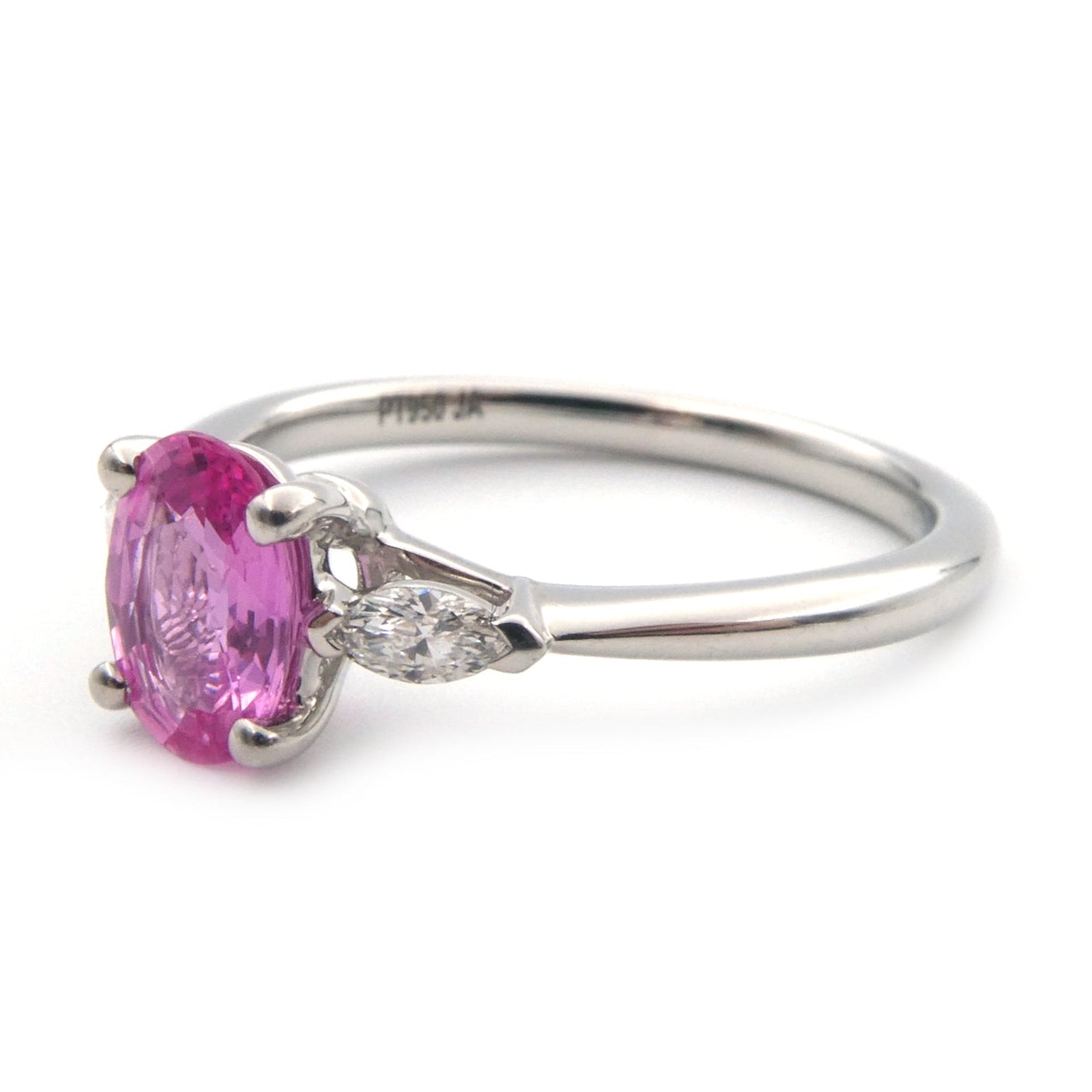 A pink sapphire and diamond three stone ring