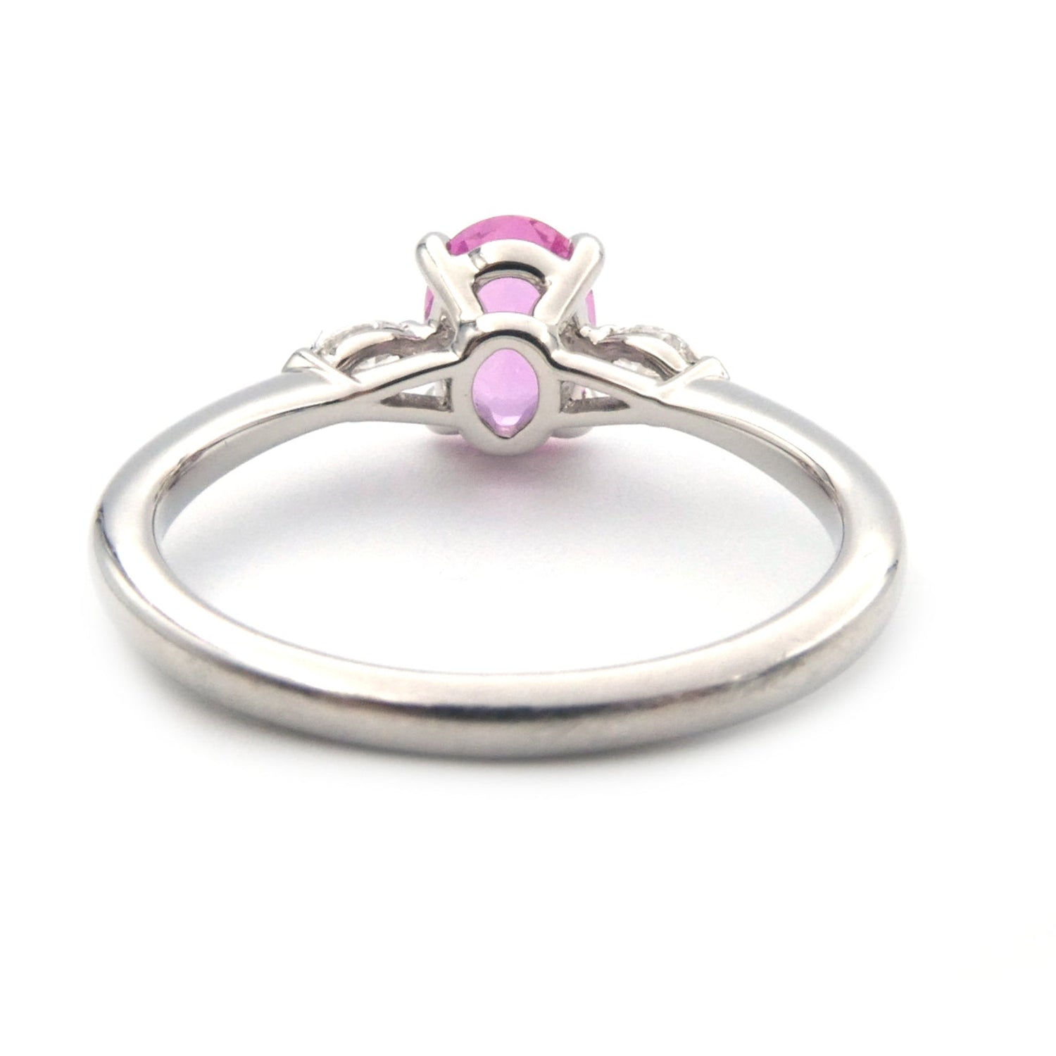 A pink sapphire and diamond three stone ring